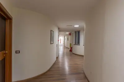 an empty hallway in a building with a wooden floor at Laura's Rooms a due passi dal Vaticano - RIONI DI ROMA in Rome