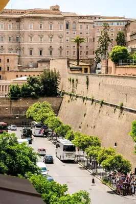 a large building with cars parked in a parking lot at Family apartment near Vatican Museum in Rome
