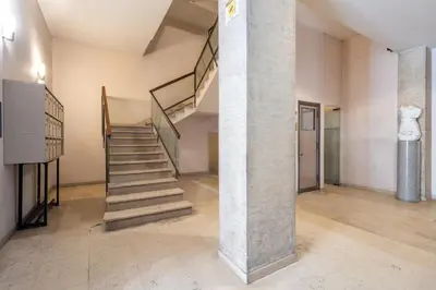 a staircase in a room with a stone pillar at iFlat Wood and Marble Riverfront in Rome