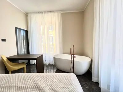 a bathroom with a tub and a table and a chair at Viminale Domus in Rome