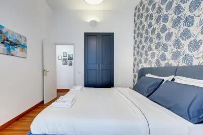 a bedroom with a large bed with a blue door at King's House - San Giovanni/Re di Roma in Rome
