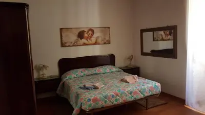 a small bedroom with a bed and a mirror at Casa Vacanze Yuli in Rome