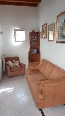 a living room with a brown couch and a chair at Casa Vacanze Yuli in Rome