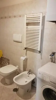a bathroom with a toilet sink and a washing machine at Casa Vacanze Yuli in Rome