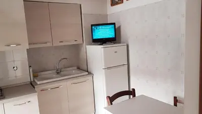 a kitchen with a tv on top of a refrigerator at Casa Vacanze Yuli in Rome