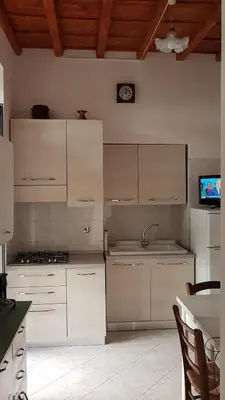 a kitchen with white cabinets and a clock on the wall at Casa Vacanze Yuli in Rome