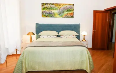 a bedroom with a bed and a painting on the wall at Karisma Suites in Rome