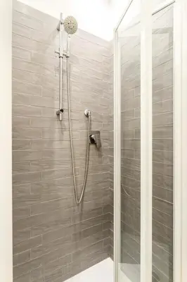 a bathroom with a shower with a glass door at First Floor Apartment in Rome