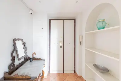 a hallway with a table and a mirror on a wall at Colosseum Perfect Apartment in Rome