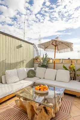 a living room with a couch and a table at ARIA Penthouse & Garden in Rome