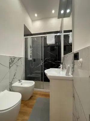 a white bathroom with a toilet and a sink at GM house Rome in Rome