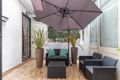 a patio with chairs and a purple umbrella at iFlat Blue Cozy Loft near Saint Peter in Rome