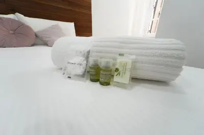 a bed with a bundle of towels and two bottles at Rome Vatican City Whole Apartment 3 Private Rooms in Rome