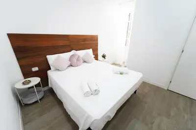 a bedroom with a white bed with slippers on it at Rome Vatican City Whole Apartment 3 Private Rooms in Rome