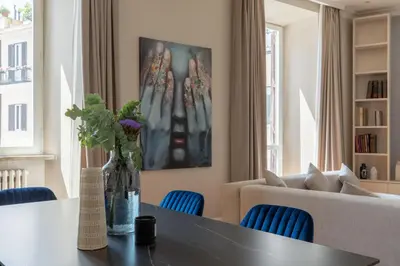 a living room with a table and blue chairs at Spanish Steps Caesar Suites in Rome