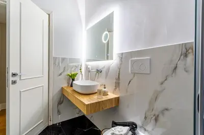 a white bathroom with a sink and a mirror at Spanish Steps Caesar Suites in Rome