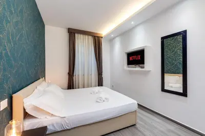 a hotel room with a bed and a tv at Spagna Boutique Suites in Rome