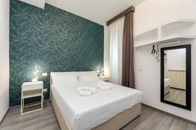 a bedroom with a large white bed and a mirror at Spagna Boutique Suites in Rome