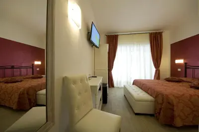 a hotel room with two beds and a mirror at Atlantis Inn Roma in Rome