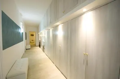 a hallway with white cabinets and a bench in a room at Atlantis Inn Roma in Rome