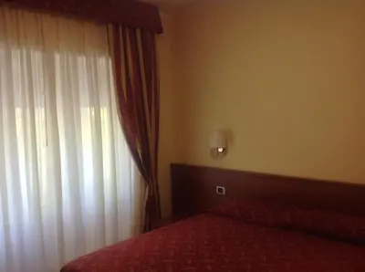 a bedroom with a bed and a window with curtains at Guglielmo Marconi House in Rome