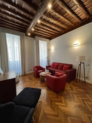 a living room with red furniture and wooden floors at DOMVS SPAGNA Via Gregoriana in Rome