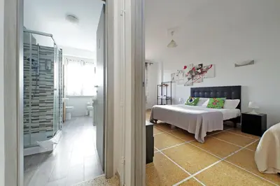 a white bedroom with a bed and a glass doorway at The colours rooms guest house in Rome