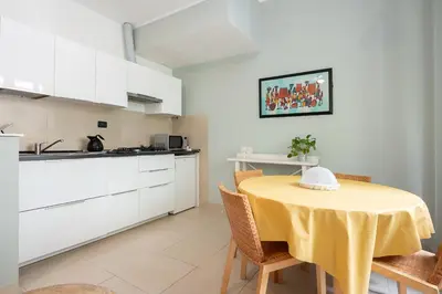 a kitchen and dining room with a yellow table and chairs at Olimpico Apartment Flaminio in Rome
