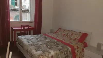 a bedroom with a bed and a table and a window at DaMa Domus in Rome