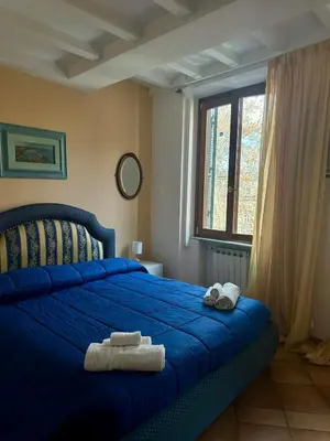 a bedroom with a blue bed with two towels on it at La Maison di Trastevere in Rome