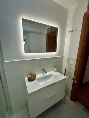 a bathroom with a white sink and a mirror at La Maison di Trastevere in Rome