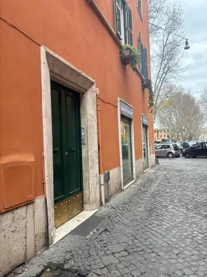 an orange building with a green door on a street at La Maison di Trastevere in Rome