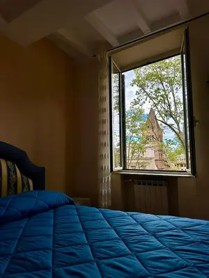 a bedroom with a bed and a window with a church at La Maison di Trastevere in Rome