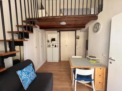 a living room with a table and a staircase at Studio flat ultimo piano in centro in Rome