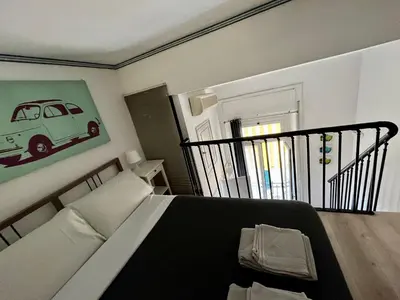 a bedroom with a bed with a picture of a car on the wall at Studio flat ultimo piano in centro in Rome
