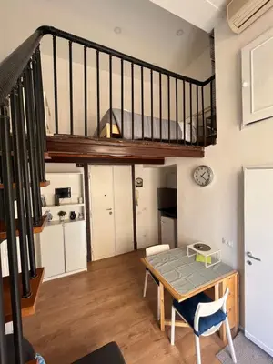 a living room with a table and a staircase at Studio flat ultimo piano in centro in Rome