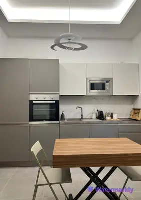 a kitchen with white cabinets and a wooden table at ITALIANAS Vatican in Rome