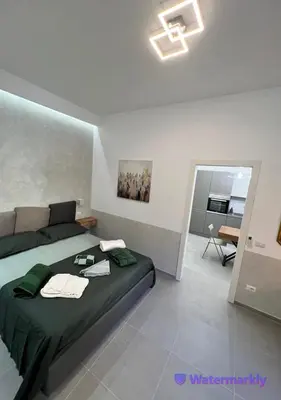 a bedroom with a bed with green sheets and a table at ITALIANAS Vatican in Rome