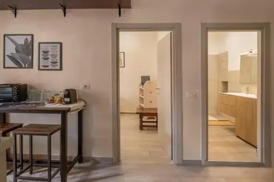 a room with a kitchen with a counter and a table at AD MAIORA SUITE in Rome