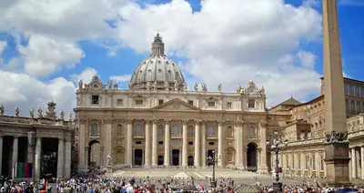 a large building with a domed building with a crowd of people at Vatican Inside House in Rome