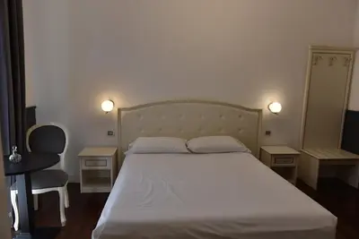 a bedroom with a bed and two tables and a chair at Piccolo di Piazza di Spagna Suites in Rome
