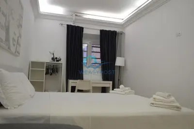 a white bed in a room with a window at Retreat in the Heart of Fori Imperiali in Rome
