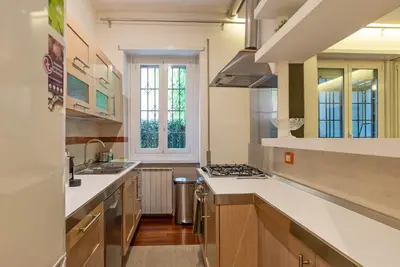 a large kitchen with white countertops and a window at Viale Tirreno - Appartamento con Patio in Rome