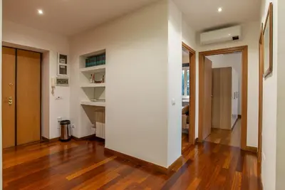 a room with a white wall and a wooden floor at Viale Tirreno - Appartamento con Patio in Rome