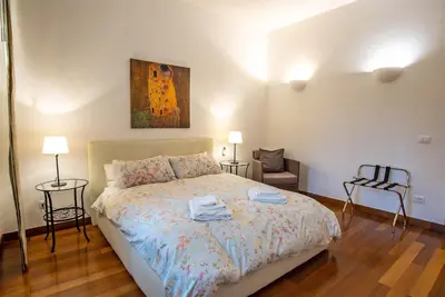 a bedroom with a bed with two chairs and a painting at Viale Tirreno - Appartamento con Patio in Rome