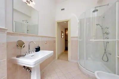 a hallway with a white door and a tile floor at Divine Vatican View Apartment in Rome