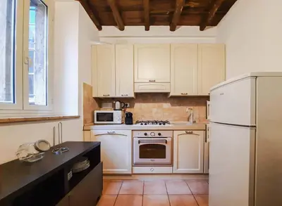 a kitchen with white cabinets and a refrigerator at EasyTopStay - Castel Sant'Angelo Cosy Flat in Rome