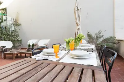 a wooden table with plates and drinks on it at Mami's Home Trastevere apt with private terrace in Rome