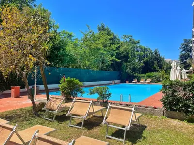 a swimming pool with lawn chairs and trees at L' oasi di Roma - Modern apartment with pool&parking in Rome