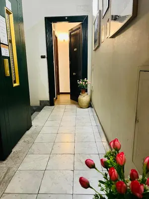 a hallway with a door and flowers on the floor at Booking Inn Settembre 95 in Rome